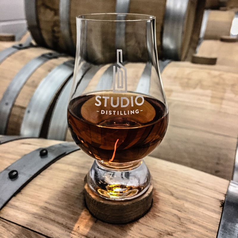 Sample galss of Studio Distilling Bourbon on a barrel