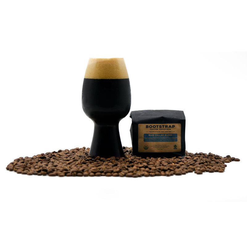 Blue Collar Coffee Stout surrounded by coffee beans and a bag of  bootstrap coffee