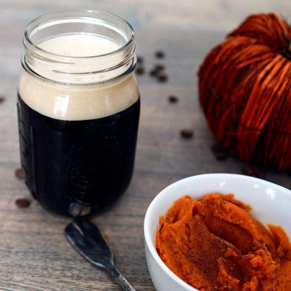 Pumpkin Spice Latte Stout in a mason jar with an adjacent bowl of pumpkin mash