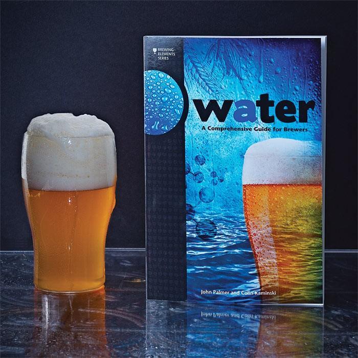 Water: A Comprehensive Guide for Brewers standing up beside a glass filled with homebrew